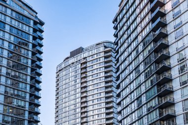 Modern apartman binası. Çok katlı, modern apartman daireleri. Balkonları ve mavi gökyüzü olan modern daireler. Vancouver Kanada-14 Ekim 2022 arası düz binalı bir apartman dairesi.