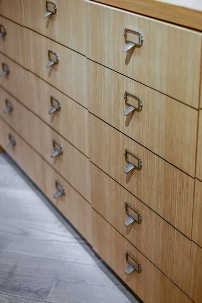 Drawers in modern furniture module. Chest Wooden Drawer. Drawers to search for book records in the library. Nobody, selective focus, blurred