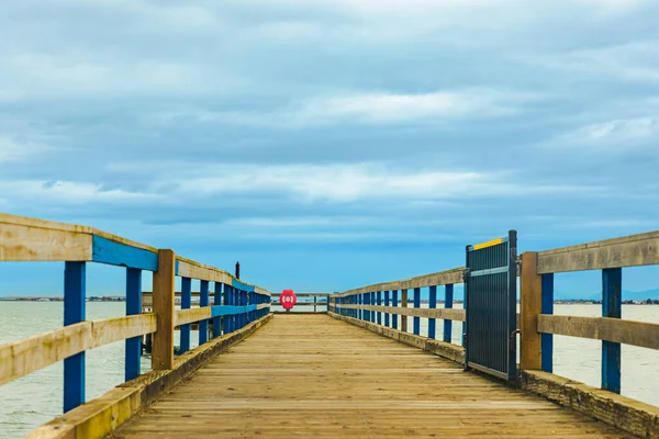 Wooden pier with sea and blue sky at the background. A wooden pier or jetty heading toward the horizon. travel photo, nobody, copy space for text
