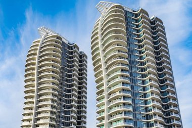 A highrise building against the blue sky. Condominium or apartment building. Looking Up Modern Building. Architecture details Modern Building Glass facade-Surrey Canada-January 10,2023