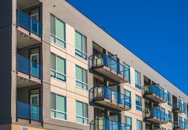 Modern apartment buildings on a sunny day with a blue sky. Facade of a modern apartment building with balconies. Multistoried new stylish living block of flats. nobody, selective focus, copy space