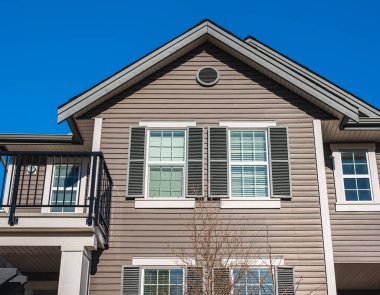 Top of a house with nice windows. Dormer in the blue sky background. Beautiful Home Exterior. Real Estate Exterior Front House in a residential neighborhood. Nobody, street photo, copyspace for text
