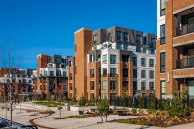 Modern apartment buildings on a sunny day with a blue sky. Facade of a modern apartment building. New apartment building. Multistoried new and stylish living block of flats, minimalistic architecture