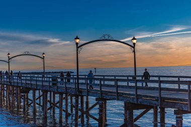 Wooden pier at White Rock, BC, Canada extends diagonally into image. Wooden Pier Walk during a cloudy sunset. Travel photo, selective focus