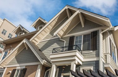 Top of a house with nice windows. Dormer in the blue sky background. Beautiful Home Exterior. Real Estate Exterior Front House in a residential neighborhood. Nobody, street photo, copyspace for text