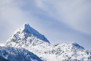 Snowy mountain peak. Mountains covered in clouds in winter in Canada. Travel photo, nobody, copy space for text