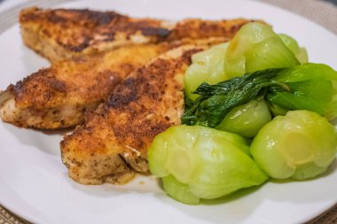 Fish dish, fried fish fillet with vegetables on white plate. Grilled Fish Fillet with green Vegetables. Tasty baked fish on a plate. Nobody, selective focus