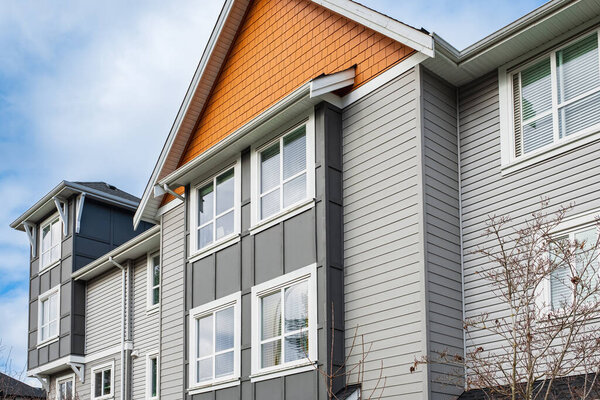 Modern apartment buildings with many windows on a sunny day with a blue sky. Facade of a new modern apartment building. Multistoried new stylish living block of flats, minimalistic architecture