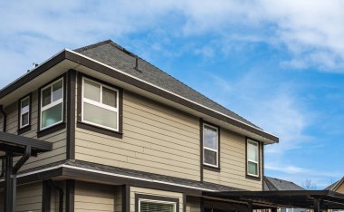 Top of a house with nice windows in the blue sky background. Beautiful Home Exterior. Real Estate Exterior Front House in a residential neighborhood. Nobody, street photo, copyspace for text