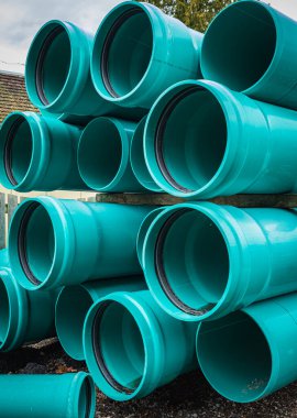 Stacks of green PVC water pipes. PVC water pipes used for construction. nobody, selective focus