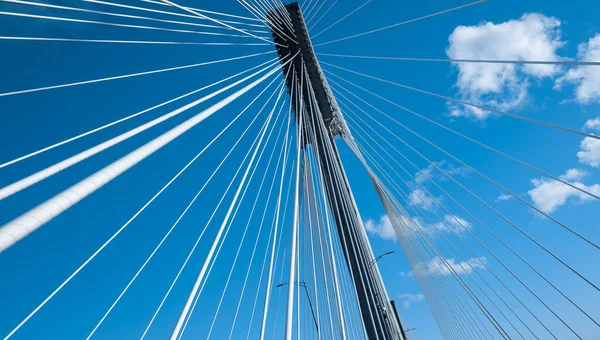Modern bridge pylon against a blue sky. Detail of the multi-span cable-stayed bridge. Linear perspective view of a white cable-stayed suspension Alex Fraiser Bridge in BC. Nobody, selective focus