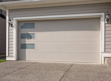 Vancouver, Kanada 'da lüks bir evin garaj kapısı. Mükemmel bir mahalle. Geniş garaj kapısı ve önünde beton yol olan bir aile evi. Hiç kimse, sokak fotoğrafı, metin için kopyalama alanı