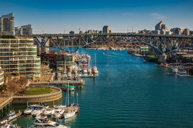 Vancouver, Kanada 'da güneşli bir günde False Creek' in panoramik hava görüntüsü. Granville Adası yakınlarındaki False Creek marinasındaki Balıkçı İskelesi iskelesinde tekne ve yatlar. Seyahat fotoğrafı - 22 Mart 2023