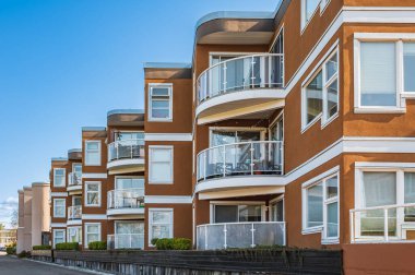 Modern ve yeni apartman. Çok katlı modern, yeni ve şık apartman daireleri. Düz binaları olan modern bir apartman dairesi. Yeni ev kompleksinin ayrıntıları. Emlak