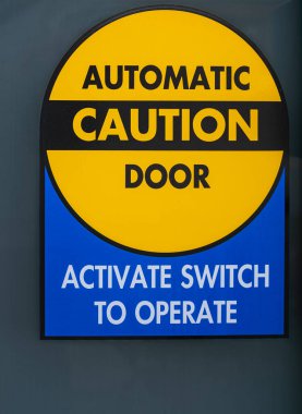 Automatic caution door sign. Automatic glass doors with yellow sign Caution. Street photo, nobody clipart