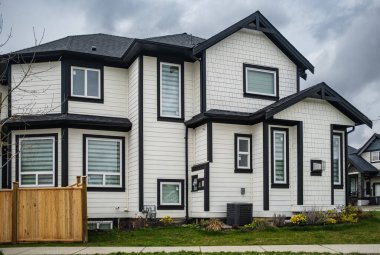 Güneşli bir günde gayrimenkul paravanı. Baharda Vancouver Kanada 'nın banliyölerinde manzarası güzel olan lüks bir ev. Sokak fotoğrafı, kimse yok.