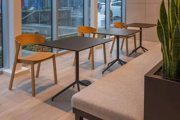 Seating in the foyer of modern office. Modern minimalist desk or worktable office with open space to work with window. Meeting tables and office chairs for conference. Nobody