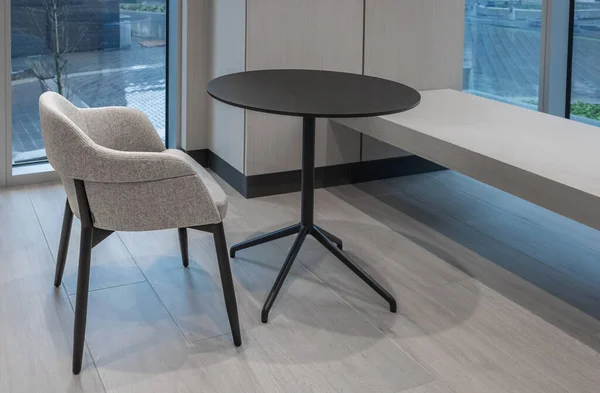 Seating in the foyer of modern office. Modern minimalist desk or worktable office with open space to work with window. Meeting round table and office chairs for conference. Nobody