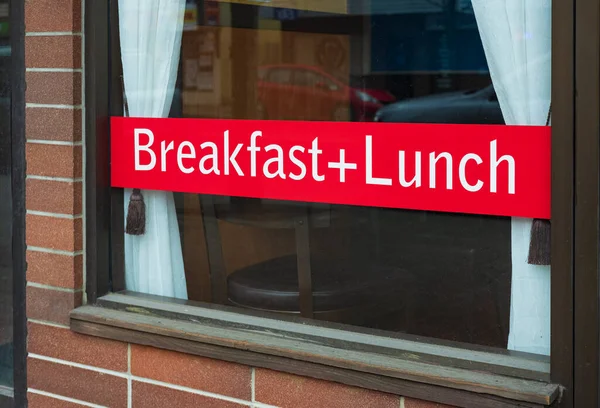 A sign in a cafe window advertising a Full Breakfast plus Lunch. Lunch break written on red advert board in a restaurant. Nobody, copy space for text