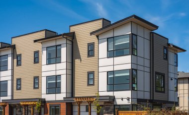 Yeni yerleşim yerleri cephesi. Surrey Kanada 'daki modern apartmanlar. İlkbaharda modern apartman kompleksi. Gayrimenkul geliştirme, satılık ev, konut piyasası kavramı