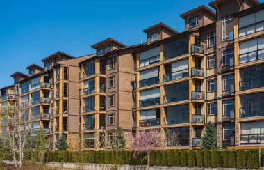 Yeni yerleşim yerleri cephesi. Surrey Kanada 'daki modern apartmanlar. İlkbaharda modern apartman kompleksi. Gayrimenkul geliştirme, satılık ev, konut piyasası kavramı