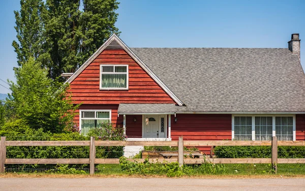 잔디와 울타리가 전형적 집이다 캐나다 시골에 나무붉은 집입니다 디자인 전통적 — 스톡 사진