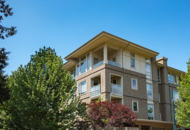 Yeni yerleşim yerleri cephesi. Surrey Canada 'da mükemmel bir mahalle. İlkbaharda modern apartman kompleksi. Gayrimenkul geliştirme, satılık ev, konut piyasası kavramı