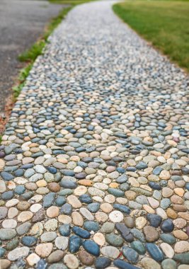 Parktaki doğal taş geçitler. Bahçedeki taş yolu. Parlatılmış taş gri çakıl taşı kaldırımı. Dokulu Cobble Pavement, Refleksoloji. Ayakta refleksoloji için kaldırımdaki çakıl taşları..