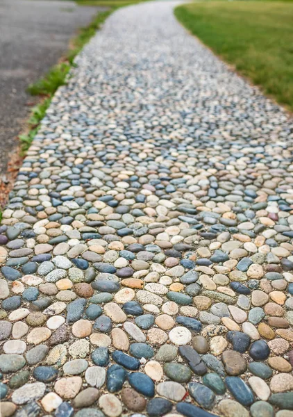 Natural stone walkways in the park. Stones path in garden.Polished stone gray pebble stone pavement. Textured Cobble Pavement, Reflexology. Pebble stones on the pavement for foot reflexology.