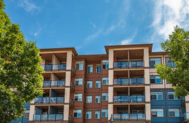Vancouver BC 'deki yeni modern apartman binaları. Kanadalı modern çok katlı mimari balkonlu ve güneşli bir yaz günü. Gayrimenkul geliştirme, satılık ev, konut piyasası