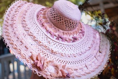 Kurdeleli ve dokunmuş çiçekli yaz pembe hasır şapkası. Klasik Panama şapkası, kadınların yaz mor hasır şapkası. Kimse yaklaşmasın, üstten.