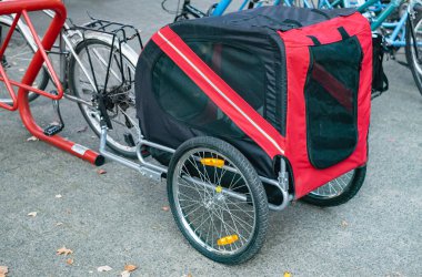 Modern dog cart on a bike. Bike dog trailer on the street. Pet cart bicycle, pet stroller for large dogs. Bicycle trailer for dog outdoor. Transportation for pets concept. Nobody clipart