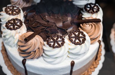 Çikolatalı pasta ve krem şantili krema. Lezzetli pastanın üstüne çikolata kreması. Lezzetli tatlı pasta. Üzerinde beyaz krema olan çikolatalı kek. Bulanık, seçici odaklanma