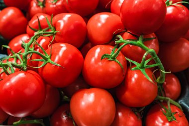 Üst üste yığılmış domatesler, domates dokusu. Seçici odaklanma, bulanık. Piyasadaki karton kutunun üzerine yerleştirilmiş lezzetli kırmızı domateslerin üst görüntüsü.