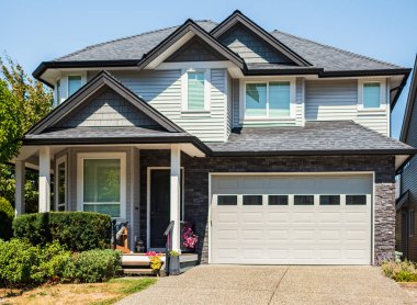 Vancouver Canada 'nın dışındaki modern ev. Güzel bir peyzaj ve garaj yolu olan büyük, modern bir ev. Modern tasarlanmış konut evinin ön görüntüsü. Banliyödeki Kuzey Amerika Evi