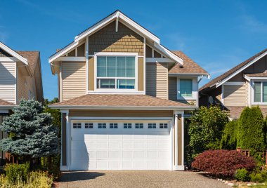Vancouver Canada 'nın dışındaki modern ev. Güzel bir peyzaj ve garaj yolu olan büyük, modern bir ev. Modern tasarlanmış konut evinin ön görüntüsü. Banliyödeki Kuzey Amerika Evi