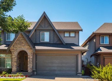 Vancouver Canada 'nın dışındaki modern ev. Güzel bir peyzaj ve garaj yolu olan büyük, modern bir ev. Modern tasarlanmış konut evinin ön görüntüsü. Banliyödeki Kuzey Amerika Evi
