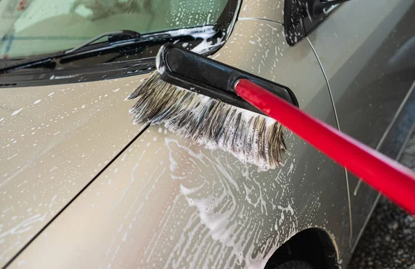 汽车司机用刷子洗车 在户外自动洗车服务中使用泡沫清洗车辆 男人在打扫他的车自助洗车概念 — 图库照片