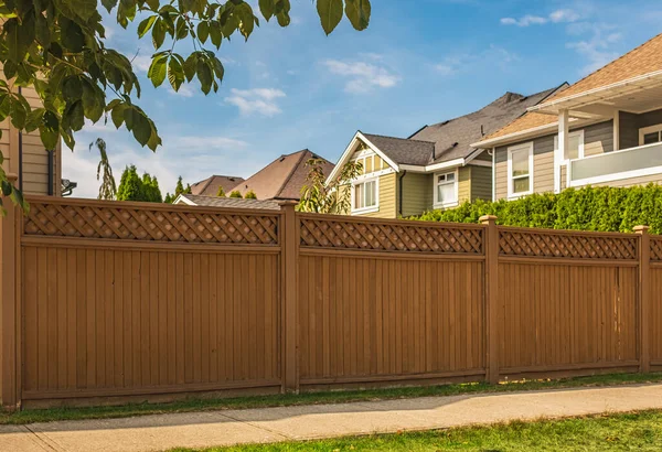 stock image Nice new wooden fence around house. Wooden fence with green lawn in a sunny summer day. Street photo, nobody. Beautiful wooden fence around the house. Solid cedar fence