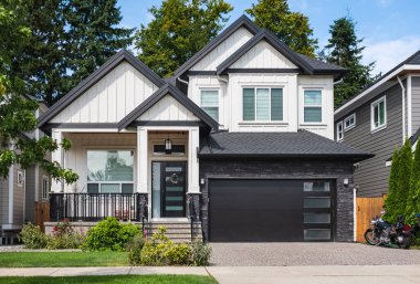 Vancouver Canada 'nın dışındaki modern ev. Güzel bir peyzaj ve garaj yolu olan büyük, modern bir ev. Modern tasarlanmış konut evinin ön görüntüsü. Banliyödeki Kuzey Amerika Evi