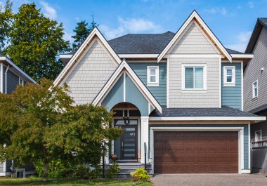 Vancouver Canada 'nın dışındaki modern ev. Güzel bir peyzaj ve garaj yolu olan büyük, modern bir ev. Modern tasarlanmış konut evinin ön görüntüsü. Banliyödeki Kuzey Amerika Evi