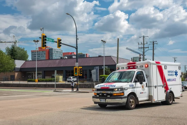 Vancouver banliyösündeki acil bir çağrıya bir ambulans cevap verdi. Vancouver ambulans arabası ve BC Ambulans Servisi insanlara yardım ediyor. Sokak fotoğrafı, 26 Temmuz 2023-Kanada