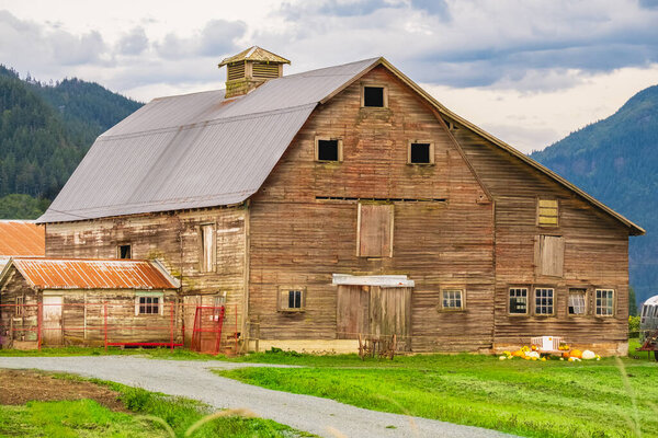 Сельский амбар в сельской местности Северной Америки. Старый деревянный амбар в поле. Традиционный деревенский амбар. Летний сельский пейзаж. Фото путешествий, концепция сельского хозяйства