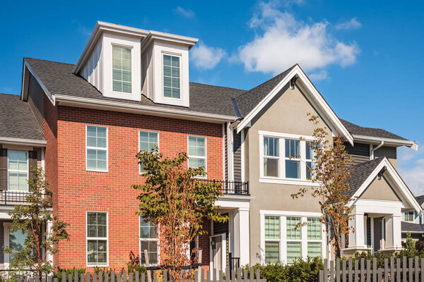 Новые современные жилые дома в Ванкувере до н.э. Современная канадская архитектура в солнечный день. Современная канадская жилая архитектура, малоэтажные новые таунхаусы. Современные дома по соседству