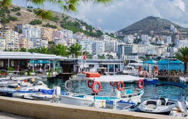 Saranda limanının şehir manzarası. İyon deniz manzarası, Arnavutluk, Avrupa 'nın sabah manzarası. Seyahat konsepti geçmişi. Güneşli bir günde İyon Denizi 'nde tekneleri olan Saranda şehri limanı - 29 Ekim 2023
