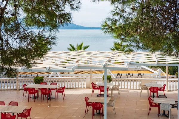 Outdoor restaurant at the beach. Table setting at tropical beach restaurant. Luxury hotel or resort restaurant with a beautiful sea view. Beautiful cafe in Albania. Outdoor restaurant, summer vacation