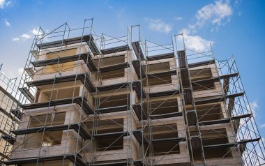 Modern apartman inşaatı. İşçiler inşaat alanında iskele ile birlikte çalışıyorlar. Gayrimenkule yatırım. Arnavutluk 'ta yeni gelişmeler. Kredi, bir daire satın alma.