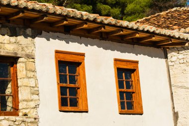 Berat 'taki ahşap pencereli eski evi seyret. Arnavutluk 'taki eski evler, unesco dünya mirası. Berat şehrinin resimli yaz manzarası. Arnavutluk 'un tarihi Berat kenti. 11 Kasım 2023