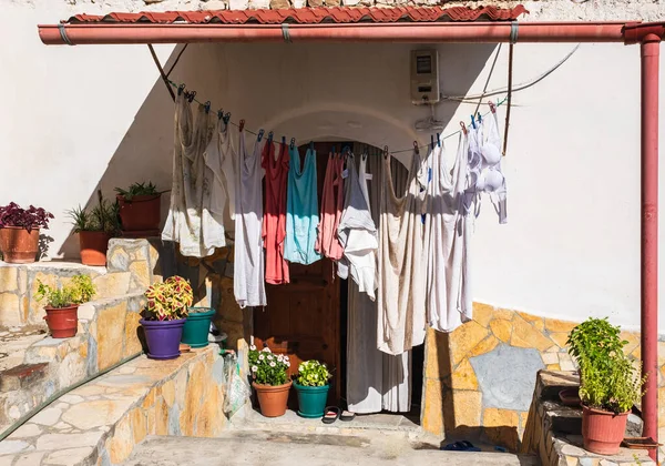 Rope with clean clothes outdoors on laundry day in rural Europe. Clothes-line laundry. Different clothes drying on laundry line at the backyard of a house. Travel photo, nobody