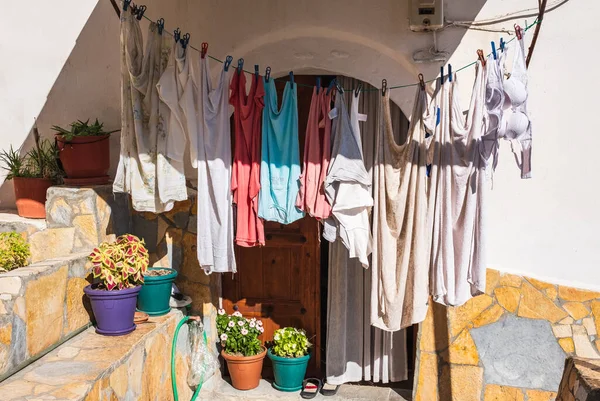 Rope with clean clothes outdoors on laundry day in rural Europe. Clothes-line laundry. Different clothes drying on laundry line at the backyard of a house. Travel photo, nobody